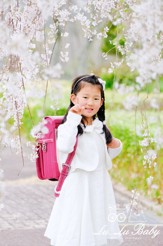 枝垂れ桜をバックに入学記念撮影